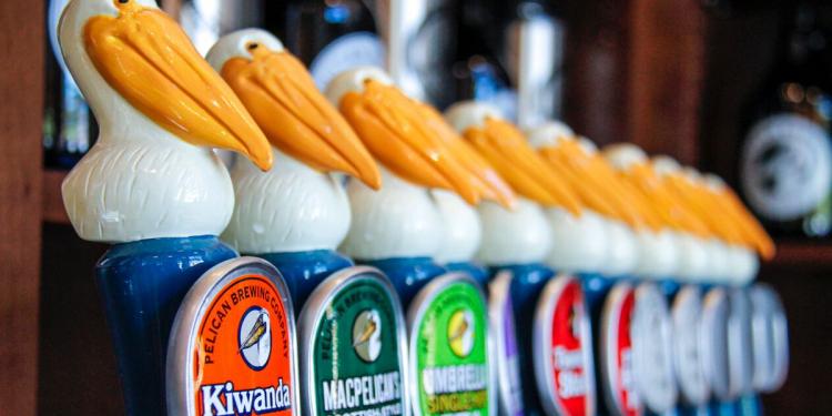 An array of beer bottles with pelican-shaped caps from Pelican Brewing.